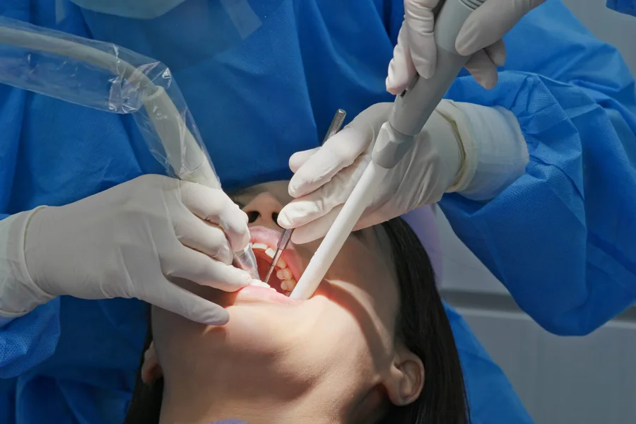 Dental hygienist polishing and cleaning a patient's teeth